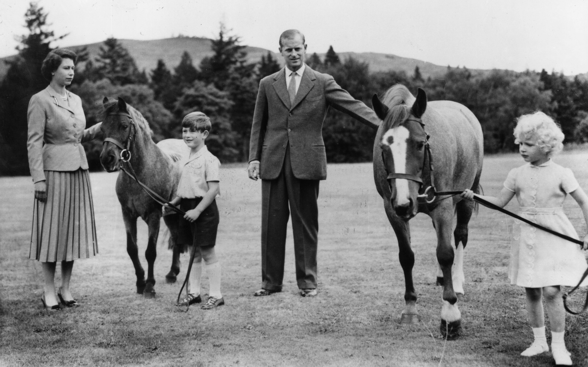 la reine Elizabeth II ; le prince Charles (plus tard prince de Galles) ; Le prince Philip, duc d'Édimbourg et la princesse Anne (plus tard princesse royale) avec deux poneys dans le parc du château de Balmoral, en Écosse. 