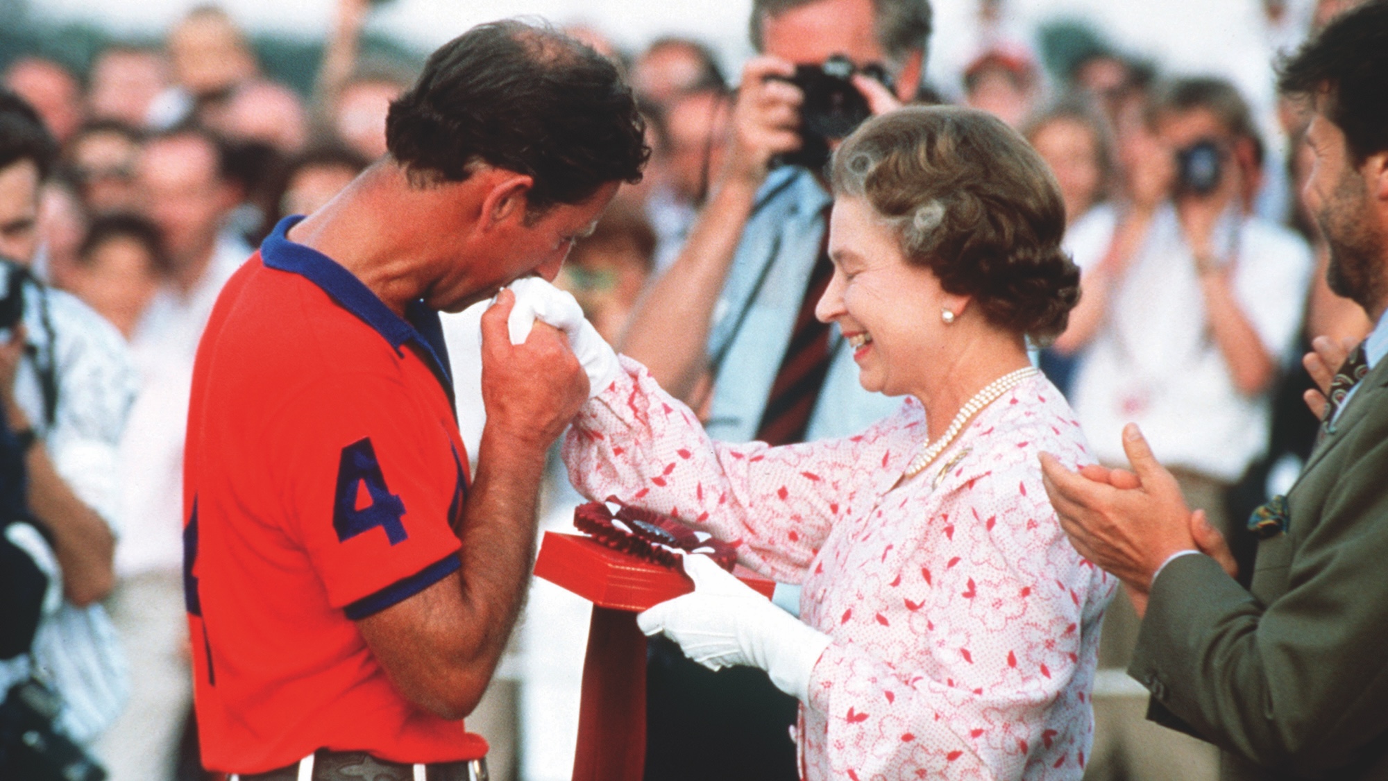 Le prince de Galles embrasse la main de la reine au terrain de polo de Windsor en 1986.
